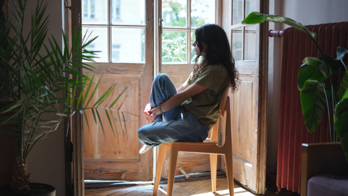 Mädchen sitzt traurig vor dem Fenster