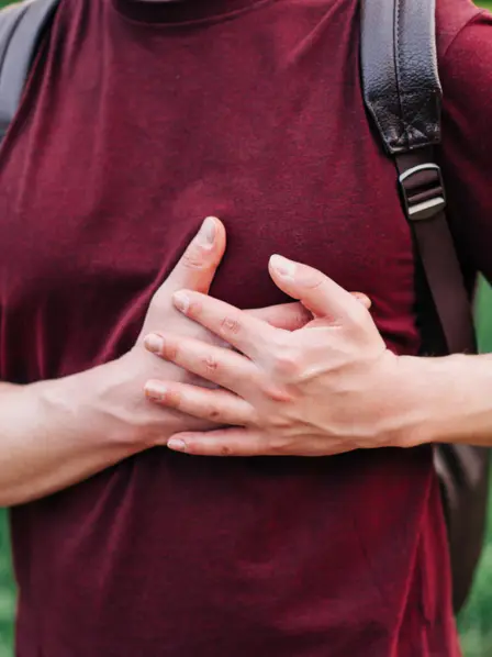 Mann im roten T-Shirt hält fässt sich ans Herz.