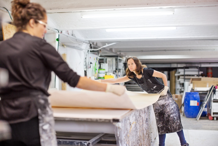 Zwei Frauen arbeiten zusammen in einer Werkstatt.