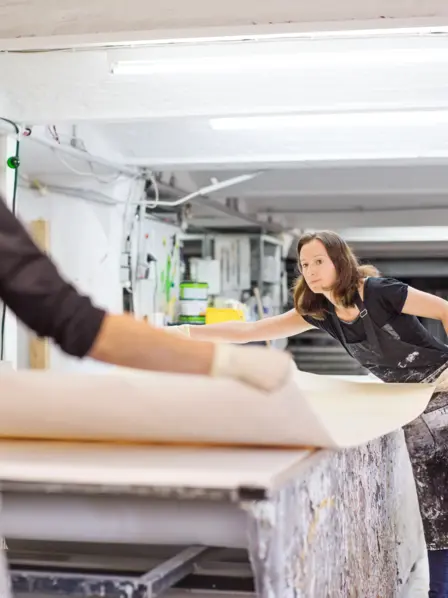 Zwei Frauen arbeiten zusammen in einer Werkstatt.