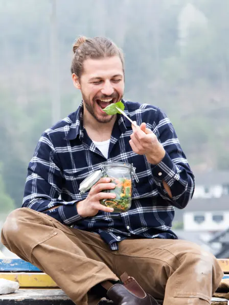 Handwerker macht Pause und isst einen gesunden Salat.