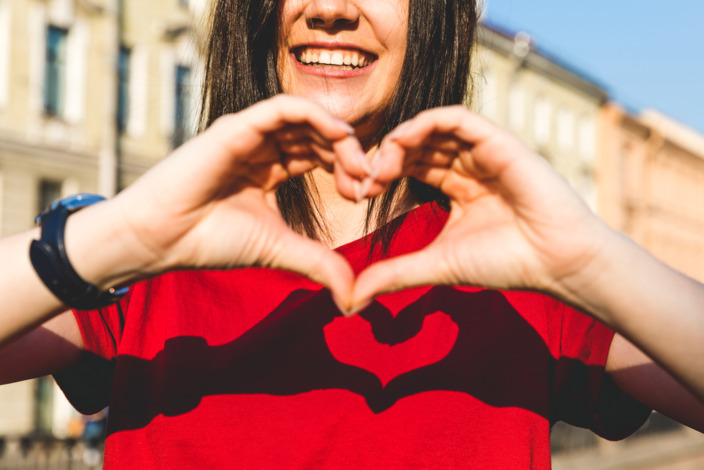 Frau macht mit ihren Händen ein Herzsymbol