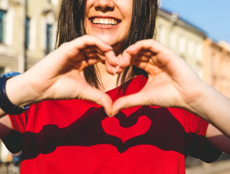 Frau macht mit ihren Händen ein Herzsymbol