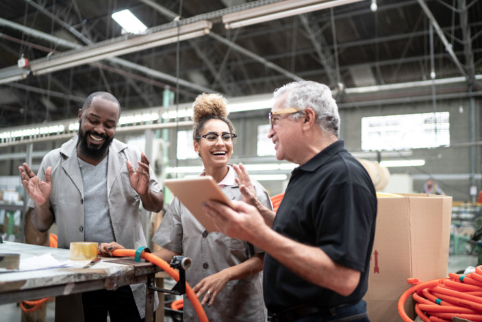 Mitarbeiter*innen mit Vorgesetzem in der Werkshalle.