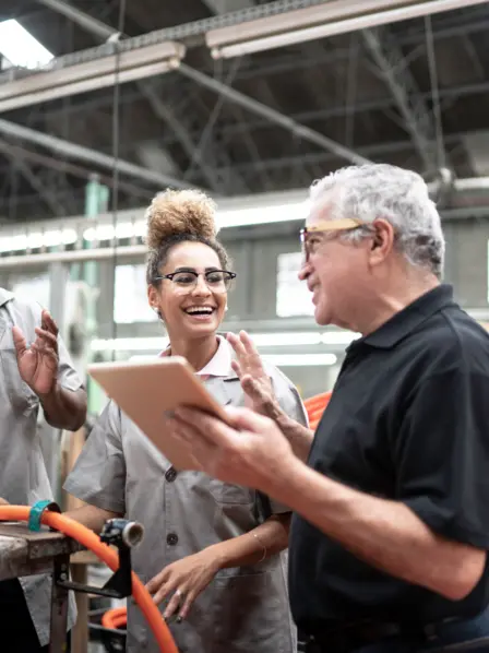 Mitarbeiter*innen mit Vorgesetzem in der Werkshalle.