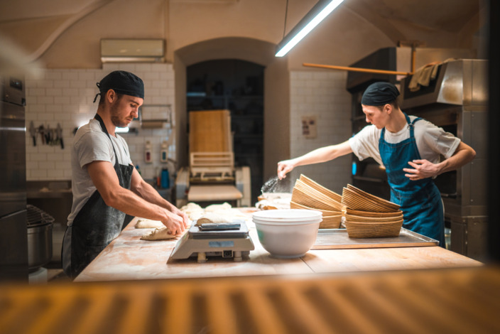 Zwei Bäcker in der Backstube bei der Arbeit.