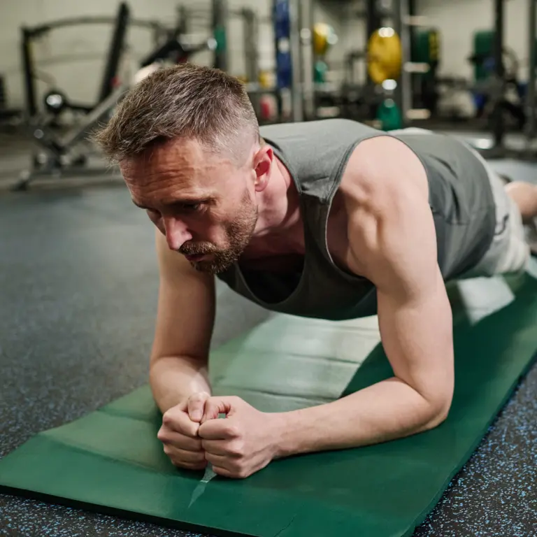 Mann macht die Plank-Übung auf der Matte