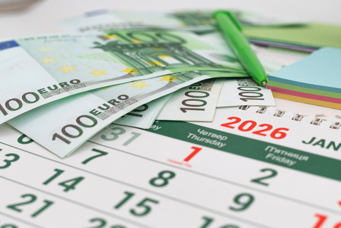 Geldscheine liegen auf einem Kalender von 2026.