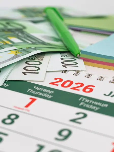 Geldscheine liegen auf einem Kalender von 2026.