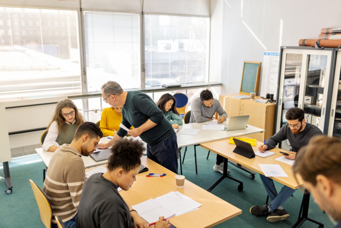 Erwachsene im Unterricht in einem Klassenraum.