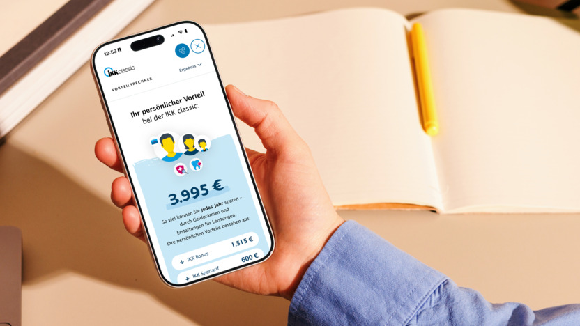 Eine Hand hält ein Smartphone fest auf dessen Bildschirm man den Vorteilsrechner der IKK classic geöffnet sieht.