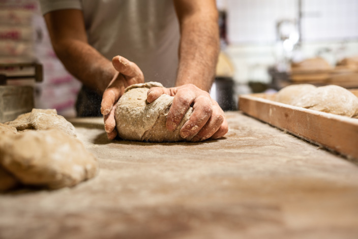 Bäcker beim Formen eines Brotlaibes