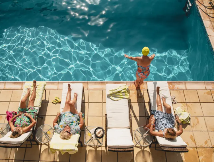Seniorinnen liegen auf Liegen beim Swimmingpool
