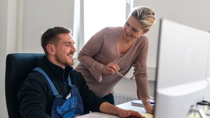 Frau redet mit Mann in Büro. 