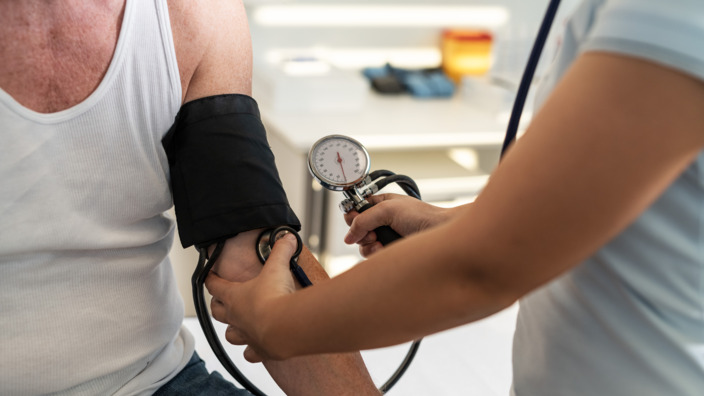 Arzt misst an Patient Bluthochdruck. 