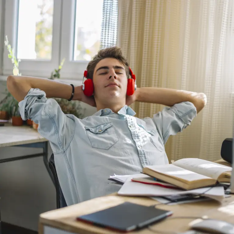 Mann mit Kopfhörern entspannt bei einem Online-Kurs.