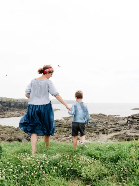 Mutter und Sohn wandern entlang eines Feldweges an der Küste