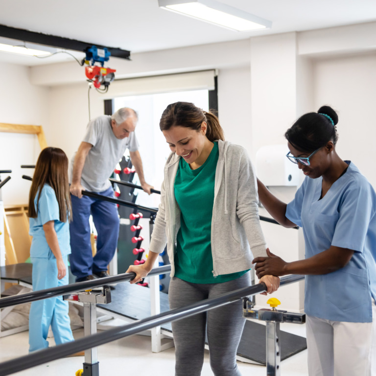Reha-Patienten lernt mit einer Physiotherapeutin wieder zu laufen