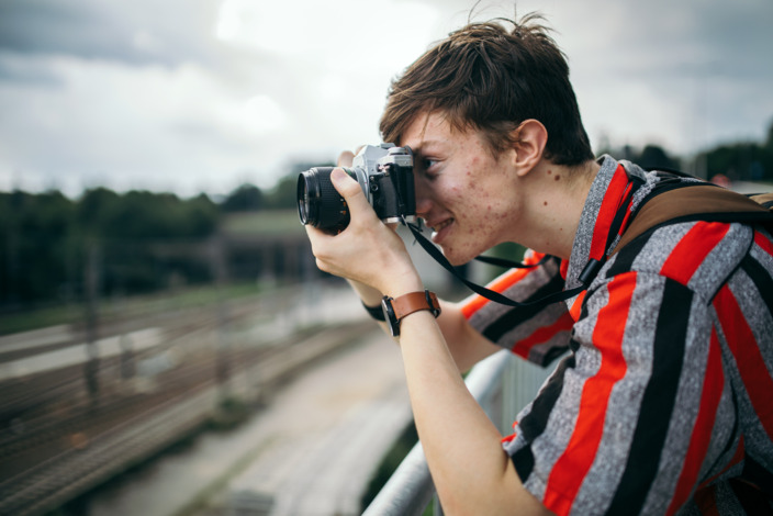 Teenager mit Hautunreinheiten fotografiert etwas