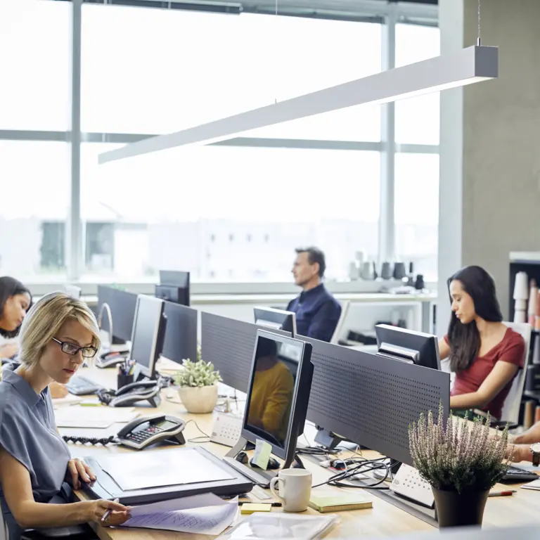 Menschen sitzen an einem großen Tisch im Büro.