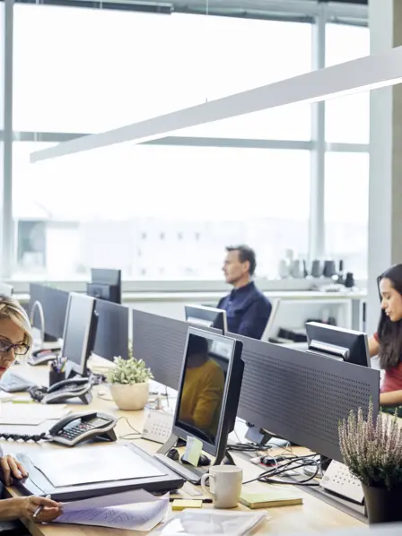 Menschen sitzen an einem großen Tisch im Büro.