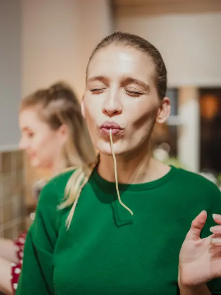 junge Frau saugt genüsslich eine Spaghetti in ihren Mund