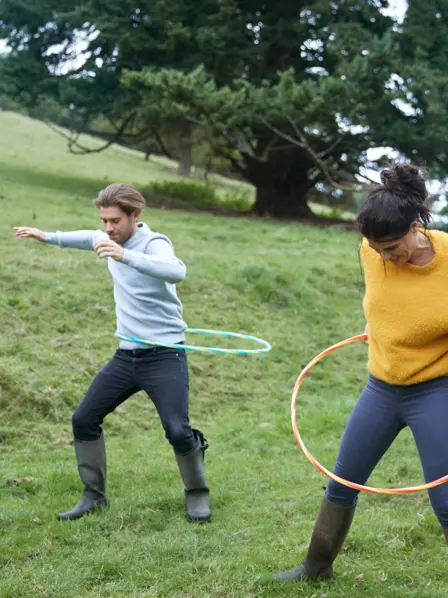 Mann und Frau benutzen Hoola Hoop Reifen.