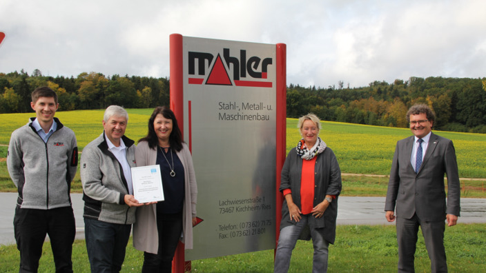 Mitarbeitende von Mahler Metallbau vor dem Firmenschild