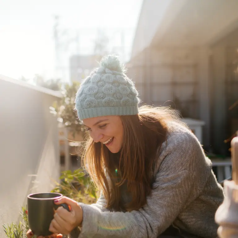 Zwei Frauen sitzen im Winter im Garten und trinken Tee.