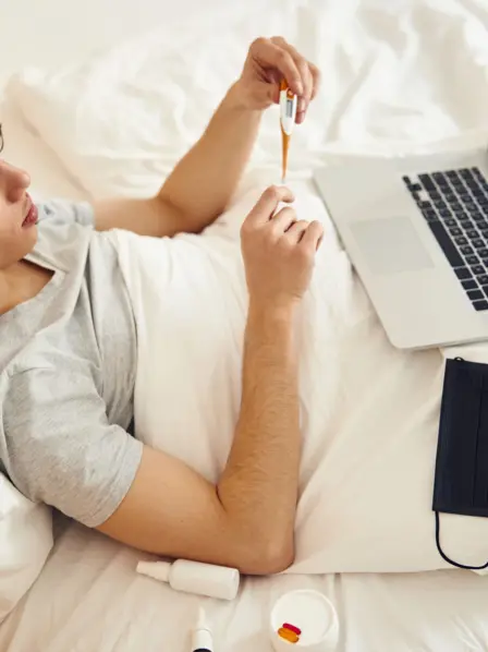 Man liegt krank im Bett und nutzt die ärztliche Beratung online.