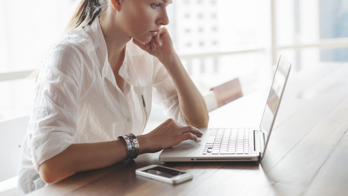 Frau tippt auf ihrem Laptop