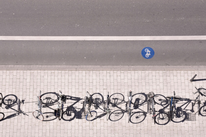 Mehrere Fahrräder stehen geparkt am Straßenrand.