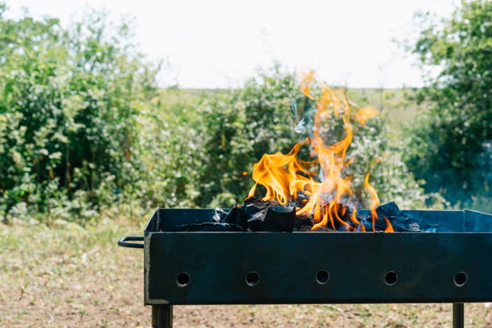 Grill im Garten mit loderndem Feuer