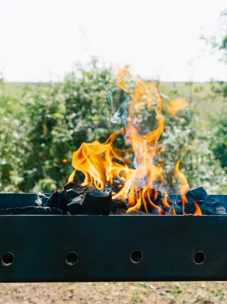 Grill im Garten mit loderndem Feuer