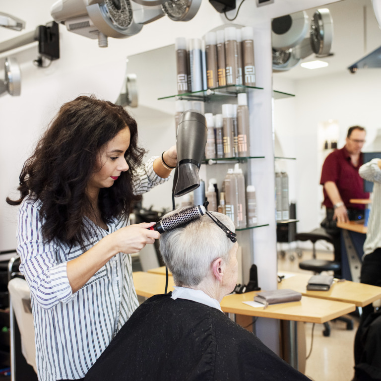 Friseurin schneidet Kundin die Haare