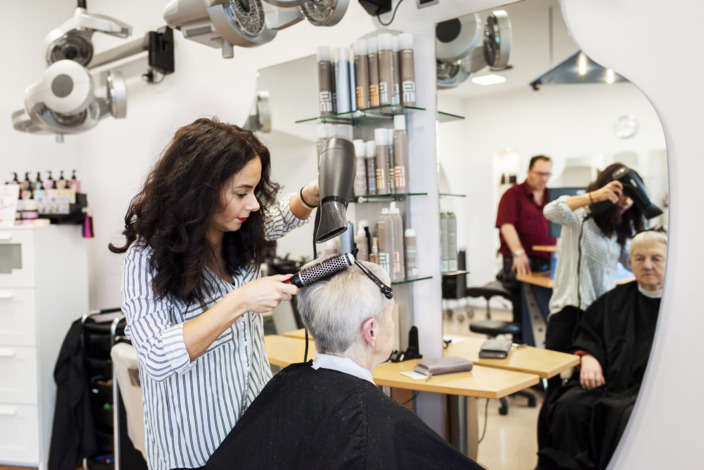 Friseurin schneidet Kundin die Haare