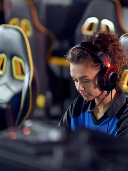 Junge Frau sitzt bei einem Gaming Wettbewerb und spielt