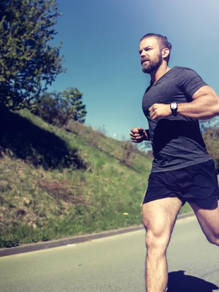 Jogger läuft auf einer Strasse im Frühling
