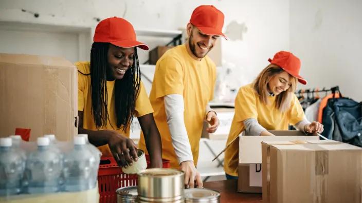 Junge Erwachsene voluntieren und helfen mit Lebensmitteln und packen.