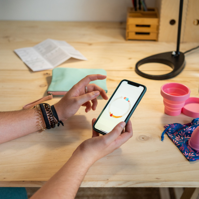 Frau benutzt eine Zyklus-App auf ihrem Smartphone