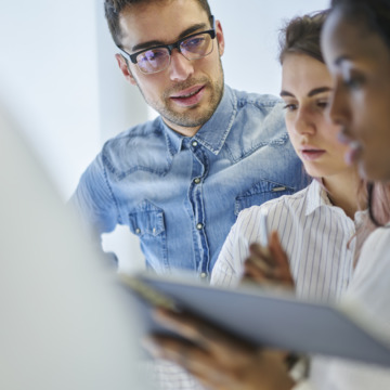 Drei Personen im Gespräch im Büro