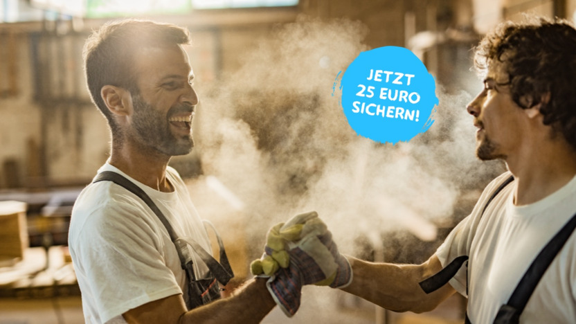 Zwei Handwerker stehen in der Werkstatt und geben sich die Hand